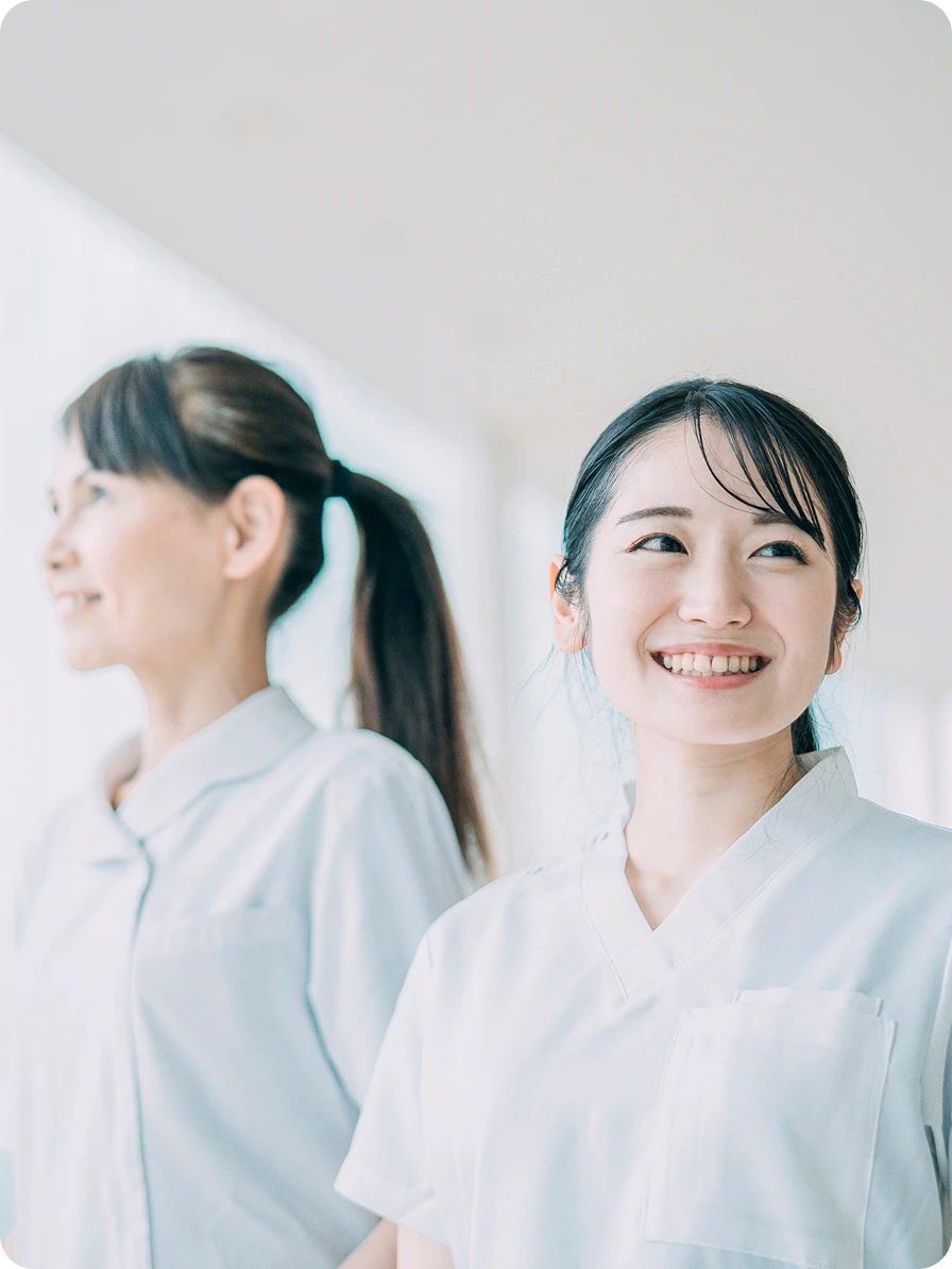 ⼊職後の研修にて、先輩スタッフから優しく⾒守られながら笑顔でレクチャーを受ける様⼦