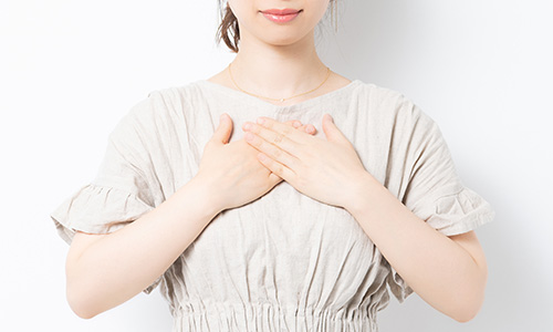 胸をなでおろし、心穏やかにリラックスする女性のイメージ
